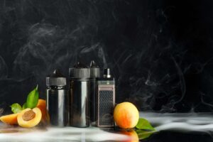 Nicotine salt vape bottles and device with a fresh peach, surrounded by mist and smoke